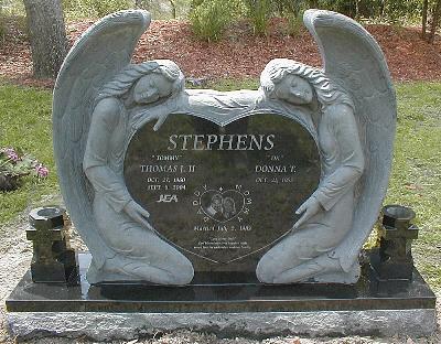 jet black granite upright monument with sculpted angels and laser etched photo